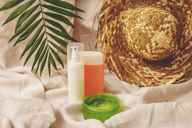 A close-up shot of sunscreen, aloe vera gel, and a lip balm with SPF arranged on a beach towel, highlighting products for sun protection and burn relief.