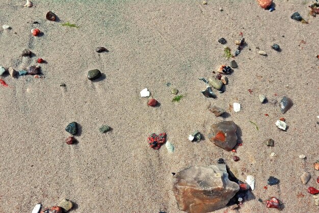 An overhead shot of a beach scene where some areas are cluttered with trash, and other areas are pristine and clean. A person is seen picking up trash in the clean area, highlighting the contrast between careless behavior and responsible action.