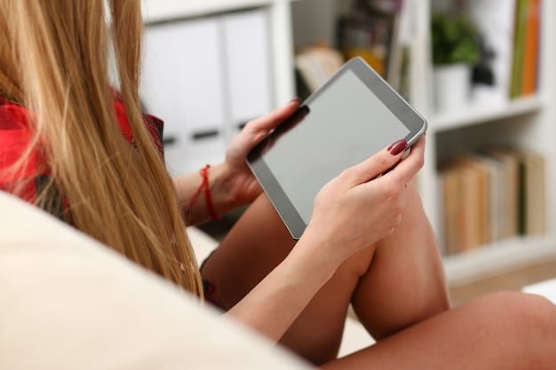 A close-up shot of an e-reader displaying a book cover, held by a person sitting in a beach chair. The ocean is blurred in the background, and the sun is shining on the e-reader screen. The focus is on the e-reader and the comfortable beach setting.