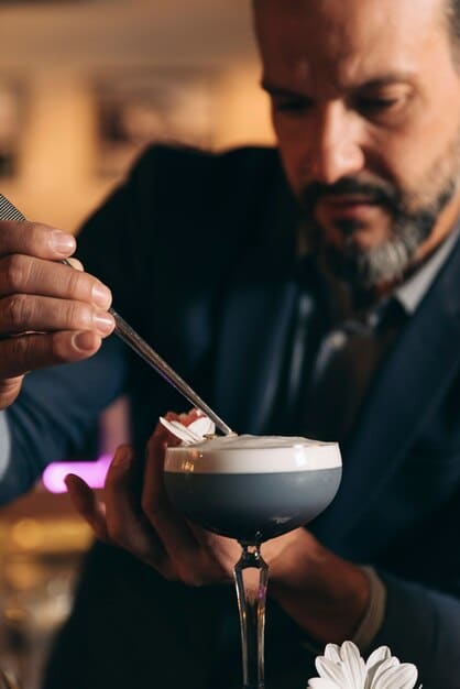 A close-up shot of a butler meticulously preparing a personalized cocktail in a luxury villa, showcasing the attention to detail and personalized service.