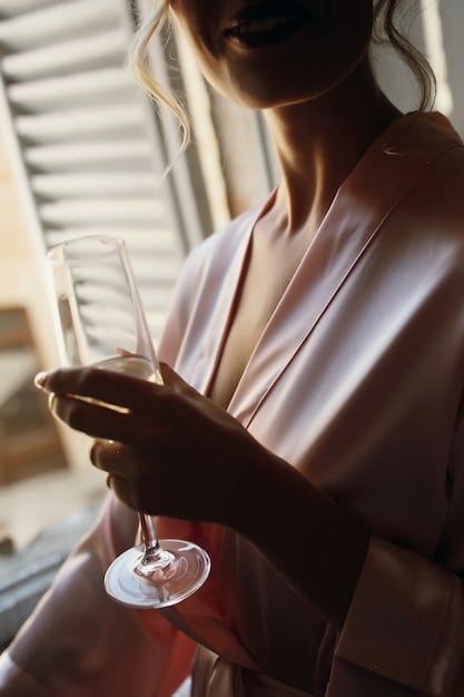A close-up shot of a personalized welcome drink being served at a luxury resort during the off-season. The drink is colorful and garnished with local fruits, with a smiling staff member delicately placing it on a table next to a plush beach towel. The background is slightly blurred, focusing on the individualized attention.