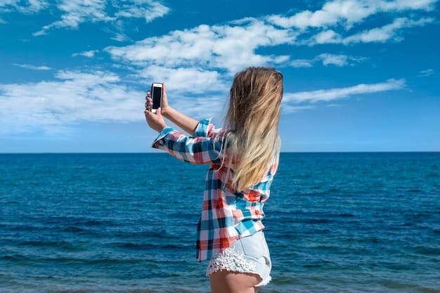 A traveler happily using a smartphone on a beach, possibly searching for deals. The ocean and beach are visible in the background, under a bright sunny sky.