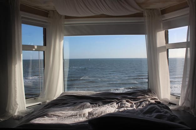 A cozy bedroom in a beachfront vacation rental with a balcony overlooking the ocean, illustrating the affordability and comfort of alternative accommodations.
