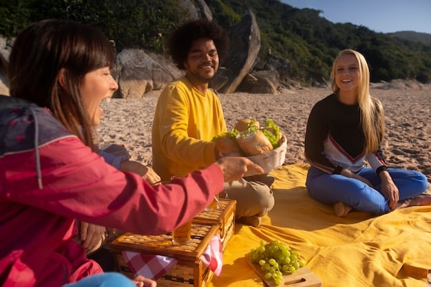A group of friends laughing and enjoying a picnic on a sunny beach, with a colorful beach blanket, a cooler filled with food, and a volleyball nearby.
