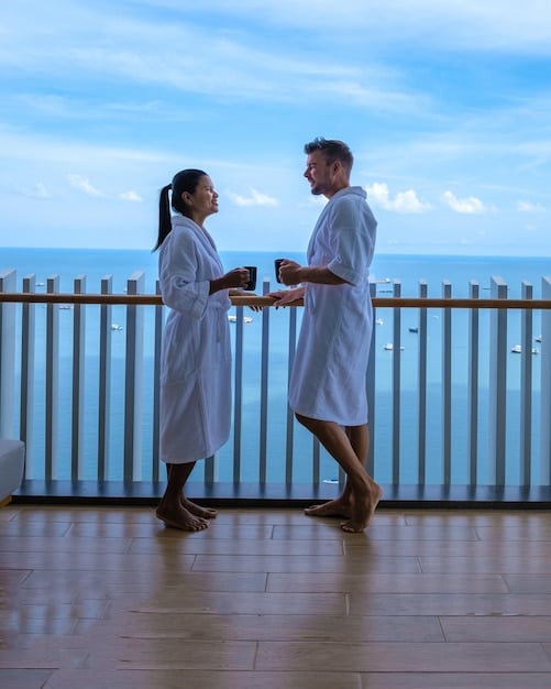 Two hands shaking in a hotel lobby with the ocean visible in the background. Both individuals are dressed in business casual attire, symbolizing a successful negotiation for accommodation.