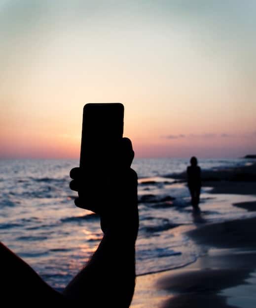 A serene beach scene at sunset, with a subtle outline of a smartphone in the foreground, symbolizing peace of mind through phone protection.