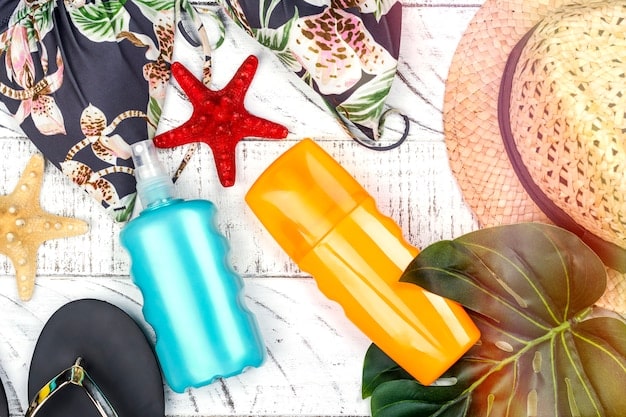 A flat lay of beach essentials, including a wide-brimmed hat, SPF hair spray, and a detangling comb, all ready for a beach day.