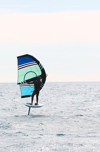 A windsurfer executing a smooth, controlled turn, with the board leaving a wake and the sail perfectly angled against the wind, showing good technique.