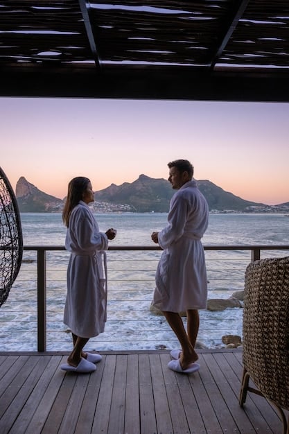 A couple relaxing in a private overwater villa at a luxury resort, with personalized butler service attending to their needs, showcasing the elevated guest experience.
