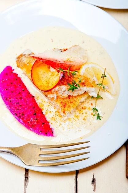 Close-up of a perfectly plated gourmet dish, likely seafood or a delicate dessert, with intricate presentation and vibrant colors, set against a subtle, luxurious dining background.