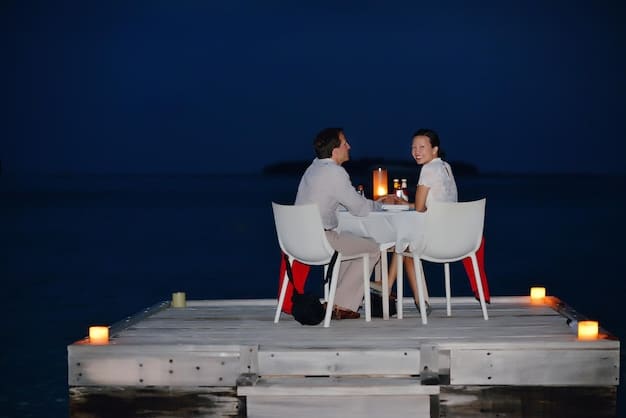 A couple enjoying a private dinner on the beach at a luxury resort, lit by lanterns, highlighting the exclusive experiences offered through elite status.