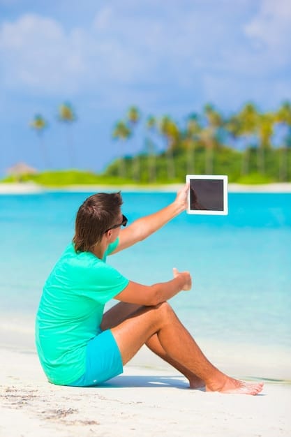 A person happily scrolling through travel deals on a tablet, with a backdrop of a tropical beach and ocean, palm trees, and clear blue skies, encapsulating the ease of digital booking for beach trips.