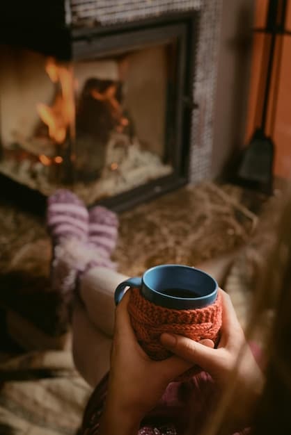 A cozy, inviting beach house living room with a fireplace, a cup of hot cocoa, and a view of a misty, quiet beach outside a large window, conveying warmth and comfort during off-season travel.