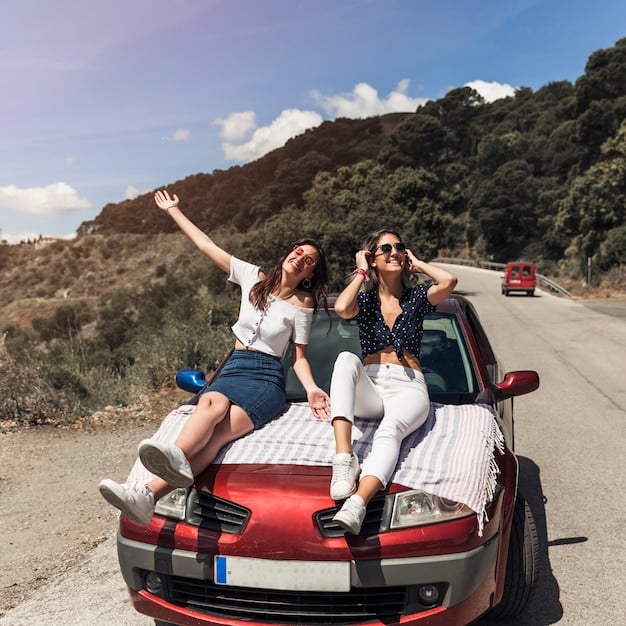 A car packed with student luggage and four friends laughing, driving down a scenic coastal highway towards a beach, symbolizing a fun and budget-friendly road trip for Spring Break.