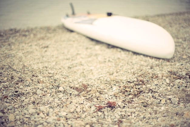 A close-up of a perfectly clean, white surfboard deck, sparkling under natural light, ready for wax application.