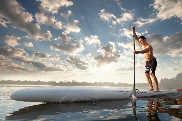 A beginner paddleboarder cautiously balancing on a board in slightly choppy water, with knees slightly bent and eyes focused on the horizon.